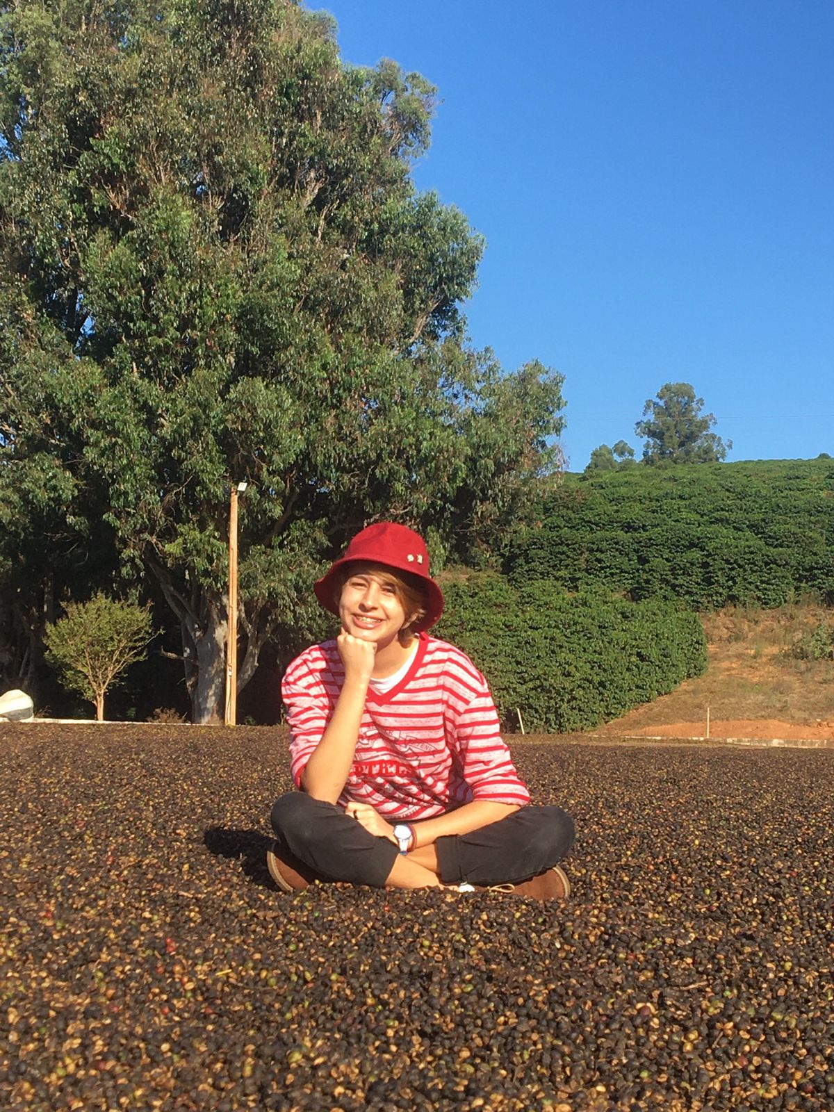 Hiolanda Condé - ogum cafe adolescente sentada no chao de uma fazenda de cafe