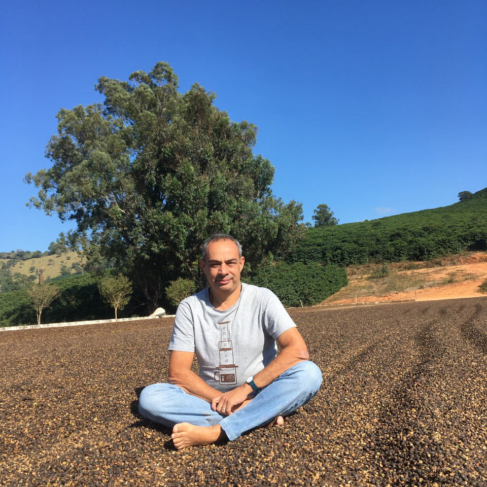 Wanderley Condé - ogum cafe homem sentado no chao de uma fazenda de cafe